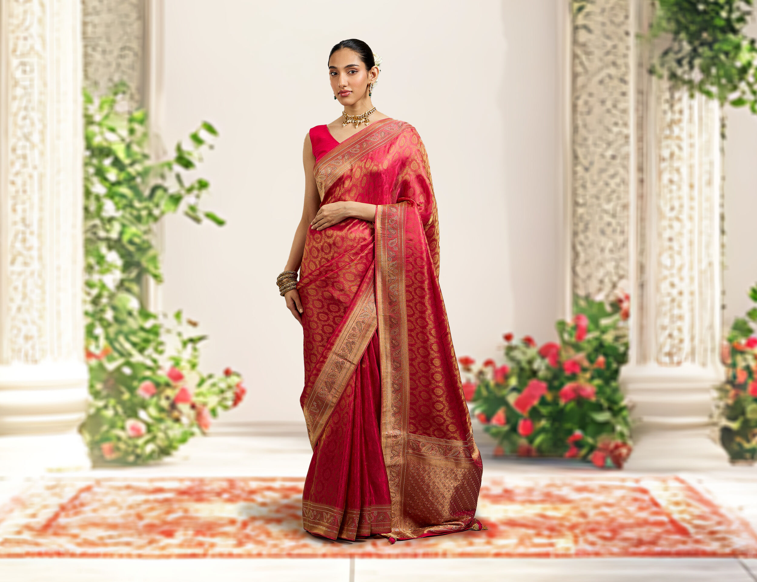Graceful bride in a traditional red floral saree, exuding timeless wedding elegance.